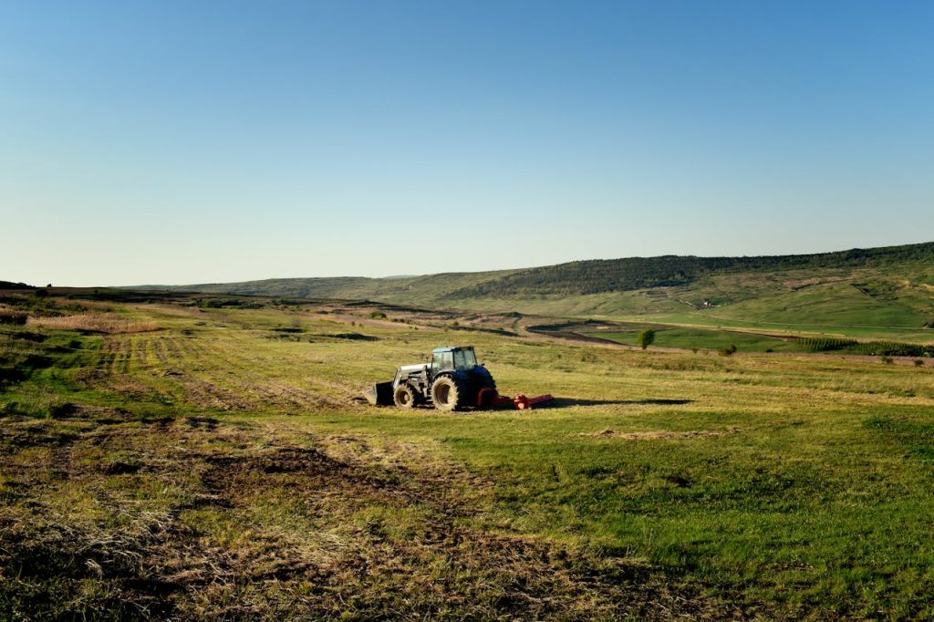 Idyllic summer day with a tractor on rolling hills in Jibert, Romania.
